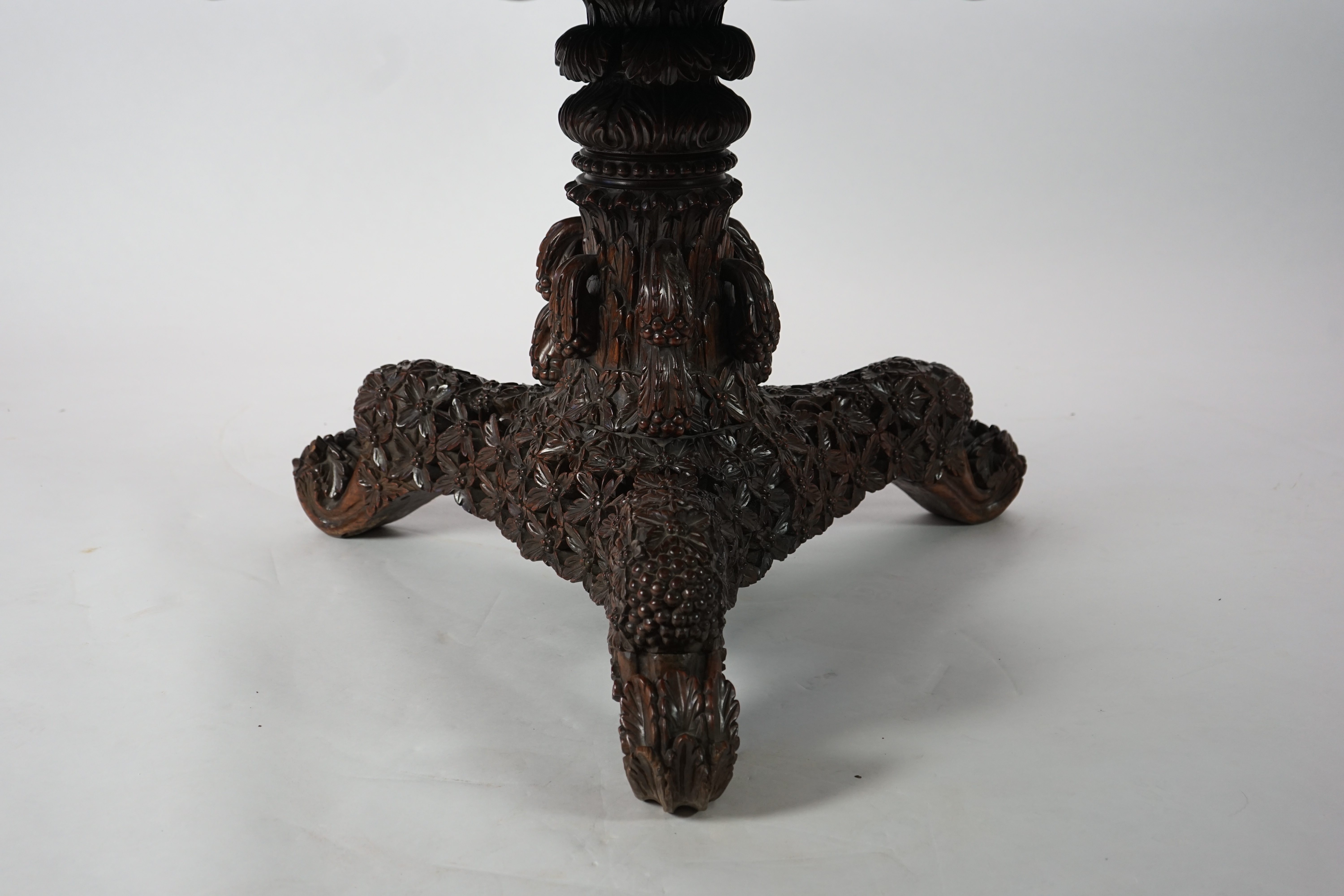 A 19th century Anglo-Indian hardwood foliate carved tilt top centre table